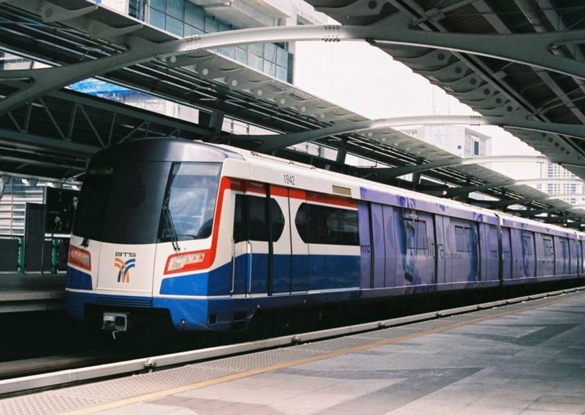 BTS Skytrain arriving at an elevated station platform in Bangkok, Thailand