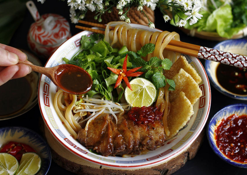 Traditional Cao Lau noodle dish with pork and herbs from Hoi An