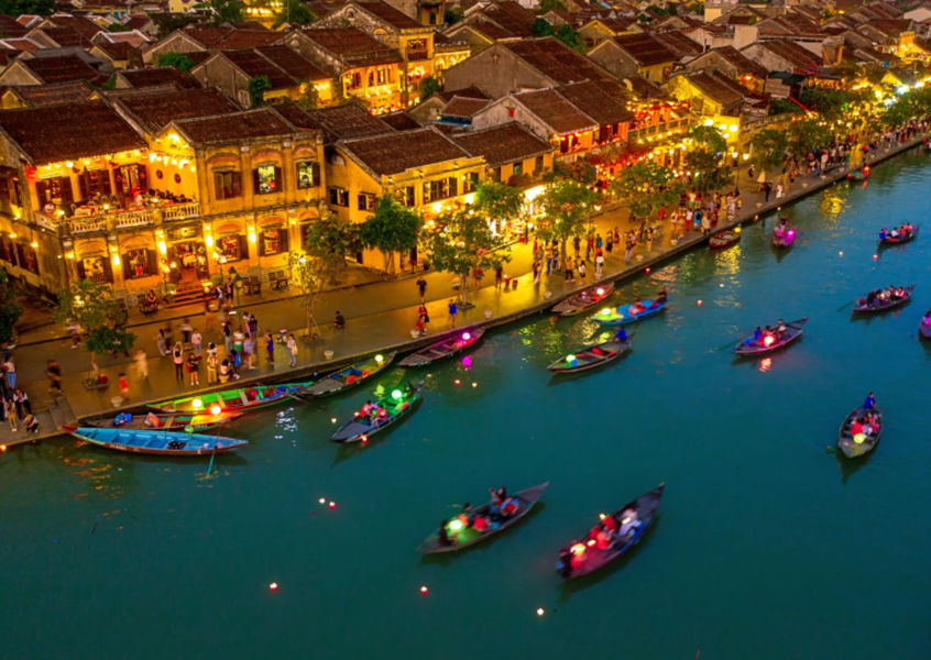 Aerial view of Hoi An Ancient Town at night with lantern boats on Thu Bon River