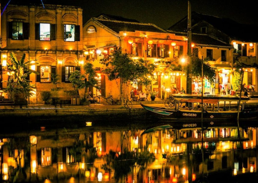 Hoi An Ancient Town riverside shophouses reflected in Thu Bon River at night