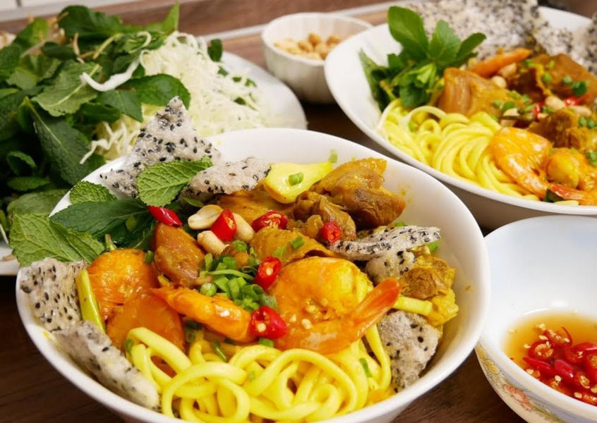 Mi Quang turmeric noodles with shrimp pork and fresh herbs Central Vietnam