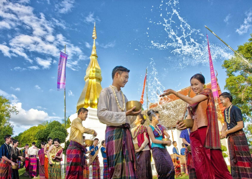 Thai people in traditional costumes celebrating Songkran water festival