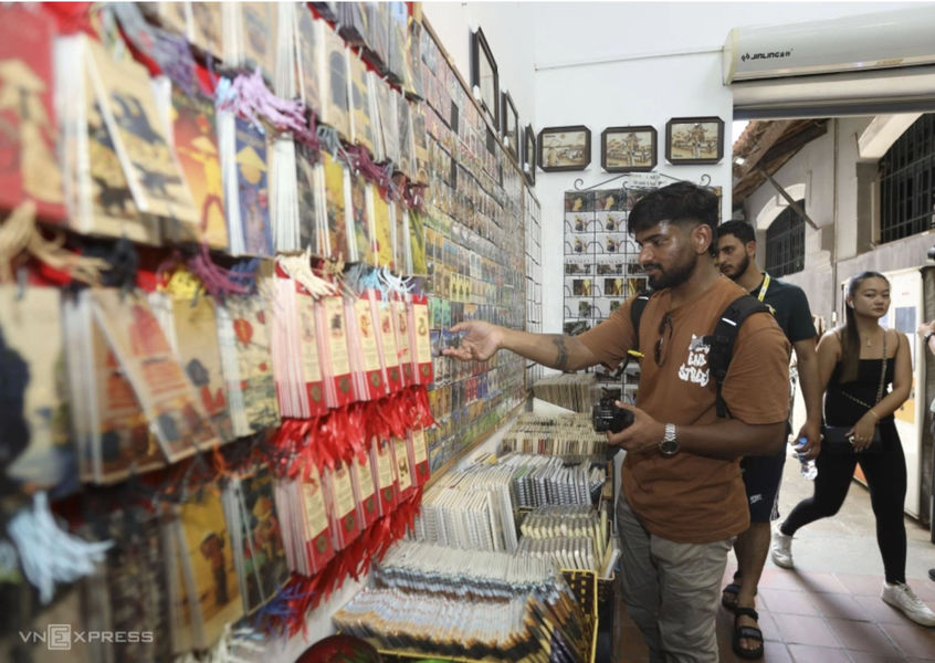 Tourist shopping for souvenirs at a Hanoi Old Quarter shop