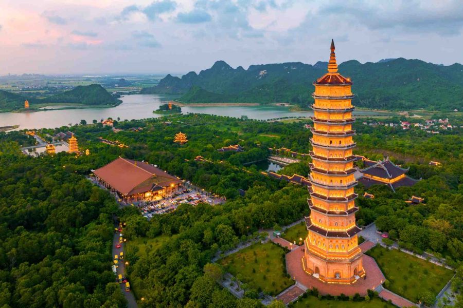 Bai Dinh Pagoda tower illuminated at sunset with temple complex