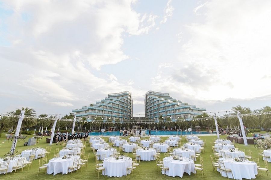 Outdoor poolside gala setup at a beachfront resort with twin towers