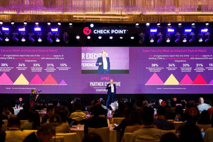 Corporate conference with presenter on stage and large screen