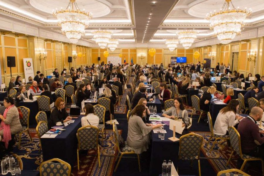 Business delegates networking at round tables in a chandelier ballroom