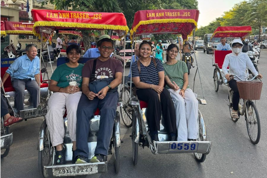 Young Indian travelers riding cyclos through Hanoi Old Quarter