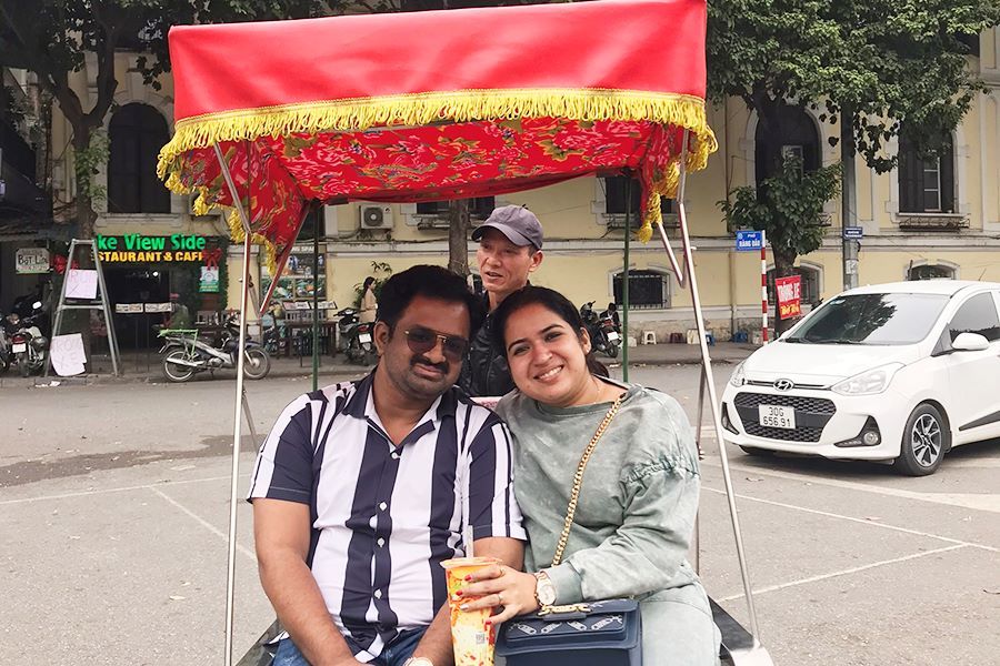 Indian travelers riding a cyclo through Hanoi Old Quarter, Vietnam