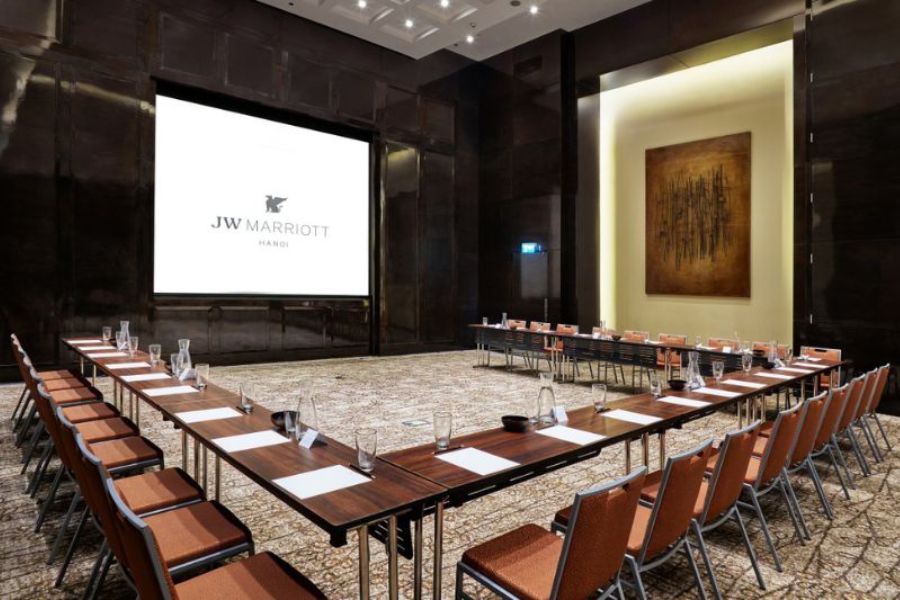 Boardroom-style meeting setup with screen at JW Marriott Hanoi