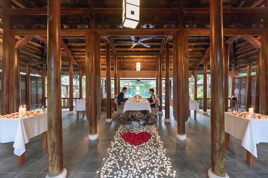 Couple dines in wooden pavilion with heart-shaped petal design