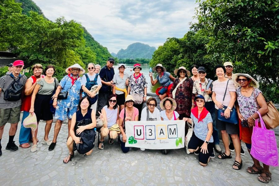 Senior travel group posing at Trang An scenic landscape, Vietnam