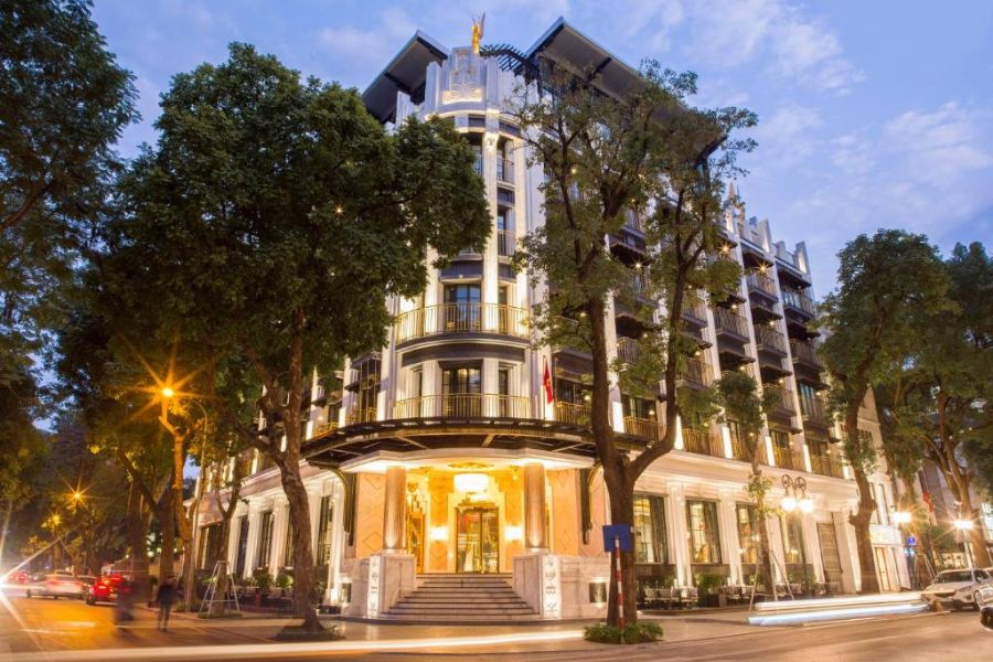 French colonial heritage hotel facade with arched balconies and rounded corner tower