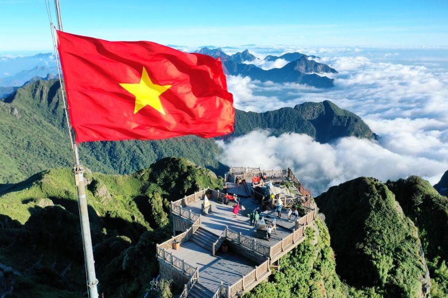 Vietnamese national flag waving over the Fansipan summit viewpoint