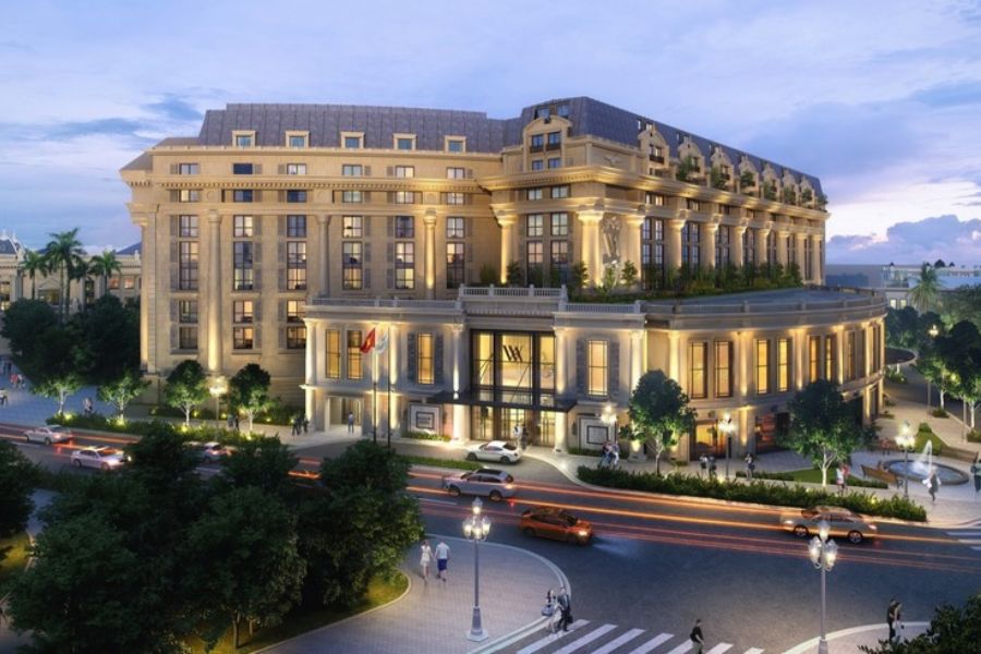 Grand colonial-style hotel exterior lit at dusk in Hanoi Vietnam