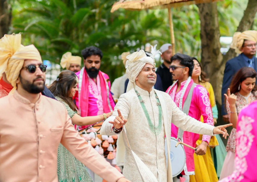 Groom dances with groomsmen during outdoor baraat procession