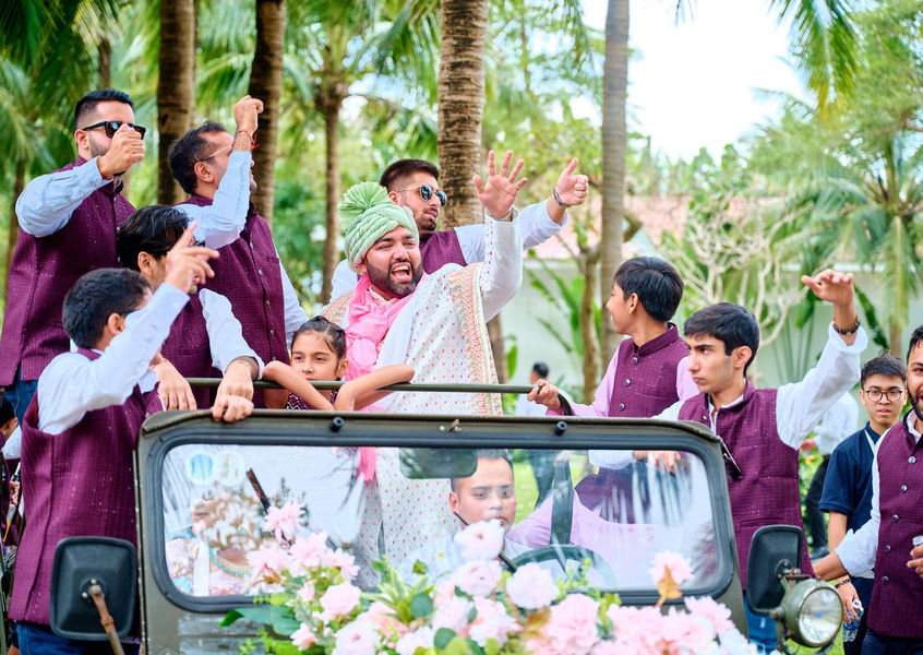 Groom celebrates atop flower-decked jeep during baraat entry