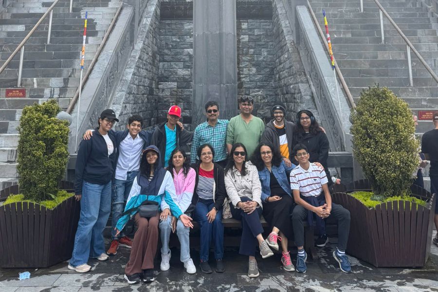 Group of Indian tourists posing together on stone steps at Fansipan, Sapa Vietnam