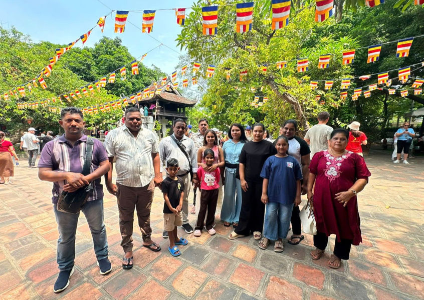Indian tourist group poses at Hanoi temple with prayer flags