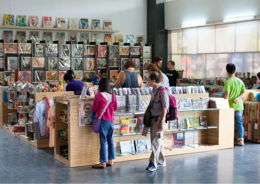Visitors browsing books and souvenirs at museum shop