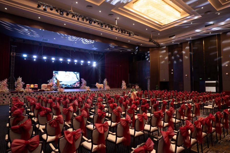 Indoor ballroom decorated with red chair sashes for a corporate gala dinner near Ha Long Bay
