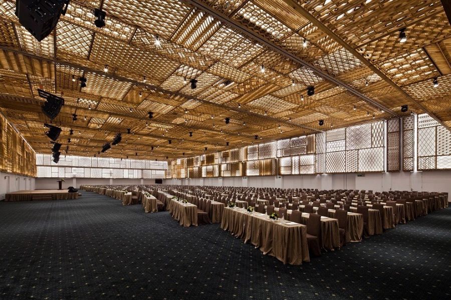 Large-capacity conference hall with woven rattan ceiling design and theater-style seating in Ho Chi Minh City