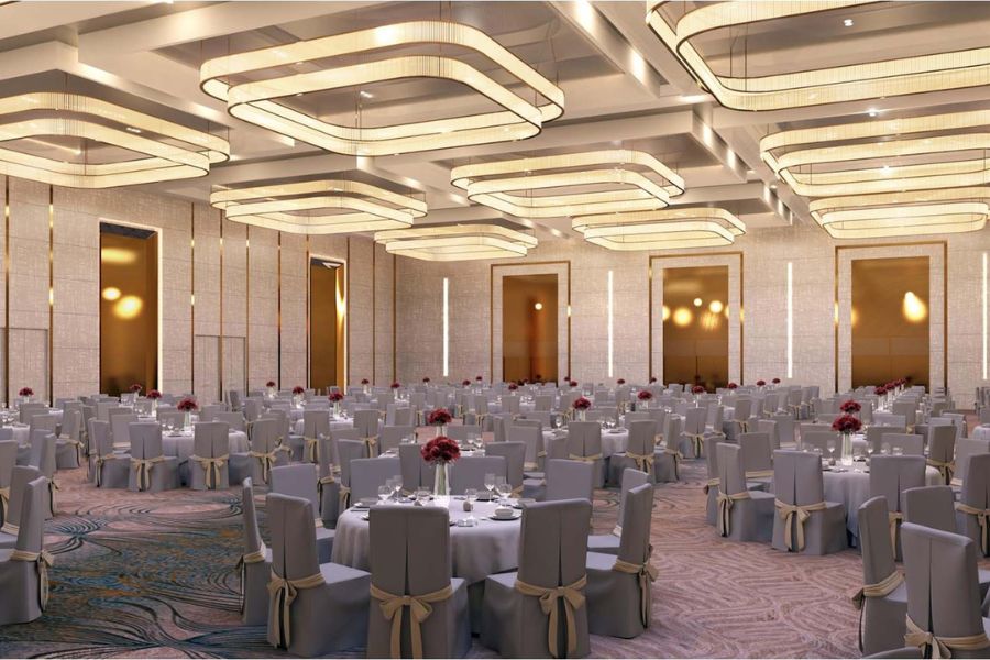 Modern ballroom with square chandeliers and round tables set for a gala dinner near Ninh Binh